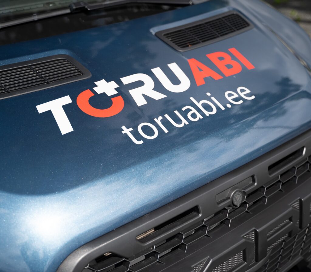 Toruabi logo ja toruabi.ee veebiaadress ettevõtte tööauto kapotil.